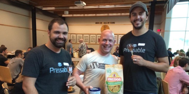 Pressable Employees pose with Shawn Hooper while exchanging gifts